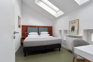 a bedroom with a bed with white pillows at PLANTONIA Aparthotel in Kraków +73 photos