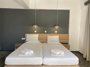 a bedroom with two beds with white pillows at Family House Faliraki Studios Apartments in Faliraki