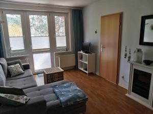 ein Wohnzimmer mit einem Sofa und einem TV in der Unterkunft Kleine Ferienwohnung am Strand in Kühlungsborn in Kühlungsborn