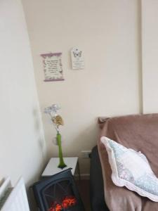 a room with a couch and a vase of flowers on a table at The Havens in Liverpool