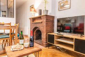 a living room with a brick fireplace and a table at L'établisement TOIMOINOU, Hyper-centre, vue marché, proche mer 150m, lits faits à votre arrivée, serviettes de toilette, ménage, inclu, Netflix, accueil en personne in Dieppe