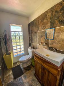 baño con aseo y lavabo y ventana en Sunset Beachside Villa, en Puerto Escondido