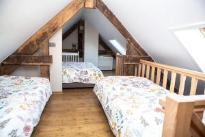 een slaapkamer op zolder met 2 bedden en een ladder bij Franciscushof in Neerpelt