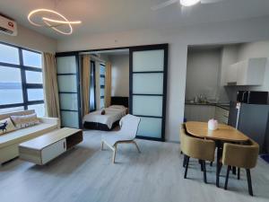 a bedroom with a bed and a table and a dining room at Jesselton Quay Citypads in Kota Kinabalu