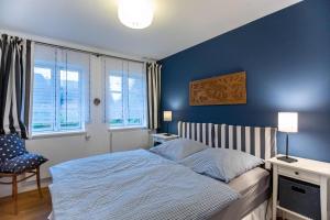 ein Schlafzimmer mit einem Bett und einer blauen Wand in der Unterkunft Ferienwohnung Abelke in Utersum