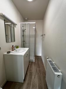 a white bathroom with a sink and a shower at Grand apt lumineux avec extérieur centre bourg 600 m plage proche Omaha Beach et pointe du Hoc in Vierville-sur-Mer