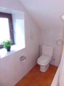 a white bathroom with a toilet and a window at casa Panticosa Sunset WOWRURAL in Panticosa