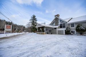 a house with snow on the ground in the driveway at The Lodge at Lincoln Peak at Sugarbush in Warren