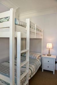 a bedroom with two bunk beds and a table at Malvern House in Deal