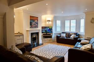a living room with a couch and a fireplace at Malvern House in Deal