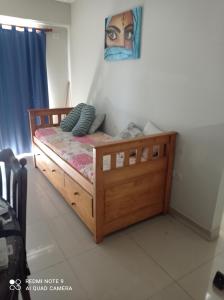 a bedroom with a wooden bed with a painting on the wall at Departamento Moderno Y Confortable in San Miguel de Tucumán