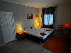 ein Schlafzimmer mit einem Bett, einem Tisch und zwei Lampen in der Unterkunft Villa Inez in Kopparberg