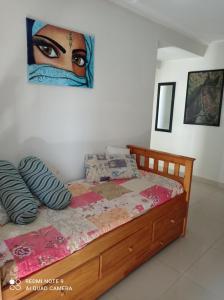 1 dormitorio con 1 cama con una pintura en la pared en Departamento Moderno Y Confortable en San Miguel de Tucumán