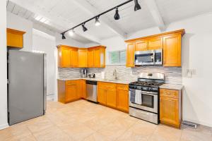 een keuken met houten kasten en een roestvrijstalen koelkast bij Drew Valley Villa in Atlanta