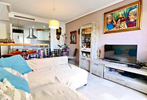 a living room with a couch and a flat screen tv at Oasis Beach in Altea