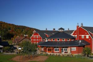 a large red building with a playground in front of it at Clay Brook Hotel at Sugarbush in Warren
