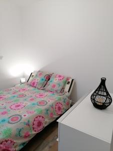 een slaapkamer met een bed en een witte tafel bij Chez Stephanie in Rang-du-Fliers