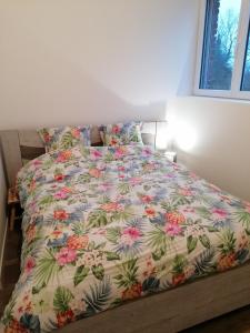 1 cama en un dormitorio con colcha de flores en Chez Stephanie en Rang-du-Fliers