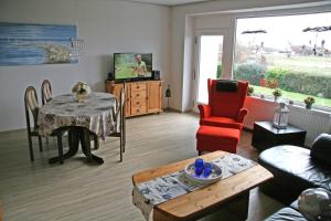 a living room with a table and a red chair at Werder Anke in Rettin