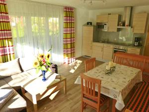 een woonkamer met een tafel en een keuken bij Ferienwohnung Kaiserblick in Sachrang