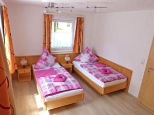 twee bedden in een kamer met roze kussens erop bij Ferienwohnung Kaiserblick in Sachrang