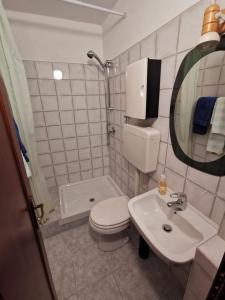 ein Badezimmer mit einem WC, einem Waschbecken und einem Spiegel in der Unterkunft Interno X Pianissolo in Millesimo