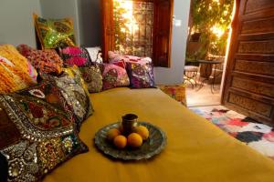 Una cama con un plato de fruta. en Riad Roxanne, en Marrakech