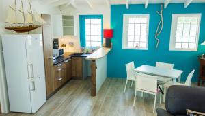 eine Küche mit einem weißen Kühlschrank und einem Tisch mit Stühlen in der Unterkunft PALM HOUSE in Oyster Pond