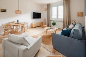 ein Wohnzimmer mit einer Couch und Stühlen und einem Tisch in der Unterkunft Kapkieker in Norderney
