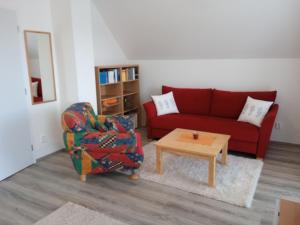 ein Wohnzimmer mit einem roten Sofa und einem Couchtisch in der Unterkunft Lipno - Villa Bernard - Lakeside Village in Frymburk