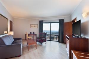 a living room with a couch and a television at Radisson Blu Resort, Malta St. Julian's in St Julian's