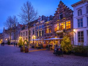 un grupo de edificios en una calle con árboles de Navidad en Grand Boutique Hotel-Restaurant Huis Vermeer en Deventer