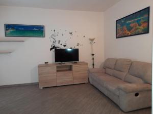 Casa Costa Outlet 2 في سيرافالي سكريفيا: غرفة معيشة مع أريكة وتلفزيون بشاشة مسطحة