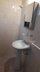ein Badezimmer mit einem weißen Waschbecken und einem Spiegel in der Unterkunft Posada Los Pájaros in Santa Rosa de Calamuchita + 21 Fotos