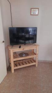 einen Flachbild-TV auf einem hölzernen Entertainment-Center in der Unterkunft Posada Los Pájaros in Santa Rosa de Calamuchita
