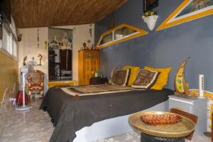 ein Schlafzimmer mit einem Bett mit gelben Kissen und einem Tisch in der Unterkunft Loft Keur Bibou in Dakar