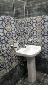 baño con lavabo y pared de azulejos en Quick continental Hotel - Jail Road, en Lahore