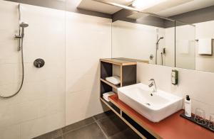 a bathroom with a sink and a shower at Hotel Traminerhof in Termeno