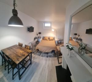 - une chambre avec un lit et une table dans l'établissement Appartement luxueux dans maison bourgeoise parisienne, à Levallois-Perret