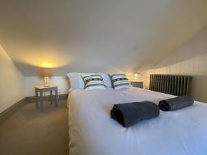 a large white bed with blue pillows on it at Mary's Cottage in Kingsdown