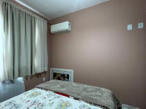 1 dormitorio con cama y ventana en Apartamento 2 dorm. em Bombas SC, en Bombinhas