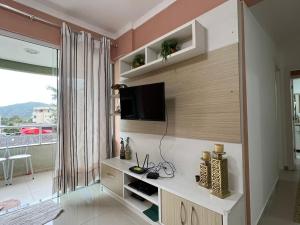 sala de estar con TV en la pared en Apartamento 2 dorm. em Bombas SC, en Bombinhas