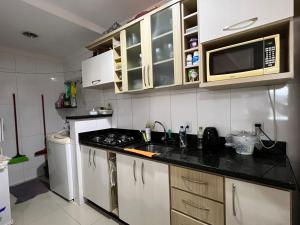 cocina con fregadero y microondas en Apartamento 2 dorm. em Bombas SC, en Bombinhas