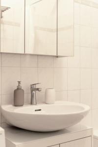 bagno bianco con lavandino e specchio di Cozy Home Vienna a Vienna