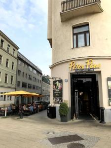 a pizza place with people sitting outside of a building at Cozy Home Vienna in Vienna