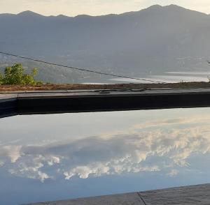 een weerspiegeling van de lucht in een plas water bij Cottage sotto il faggio centenario in Ameno