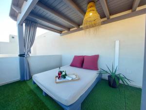 Un dormitorio con una cama con almohadas rosas. en Deep Blue Cotillo II by Sea You There Fuerteventura en El Cotillo