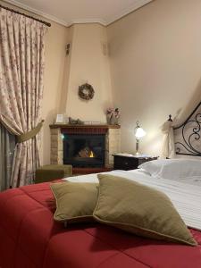 a bedroom with a bed and a fireplace at Valentini Guesthouse in Karpenision