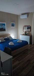a bedroom with a bed with blue sheets and a desk at VIOLET HOUSE. in Catania