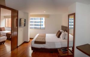 a hotel room with a bed and a mirror at Hotel Confort 80 Zona Rosa in Bogotá